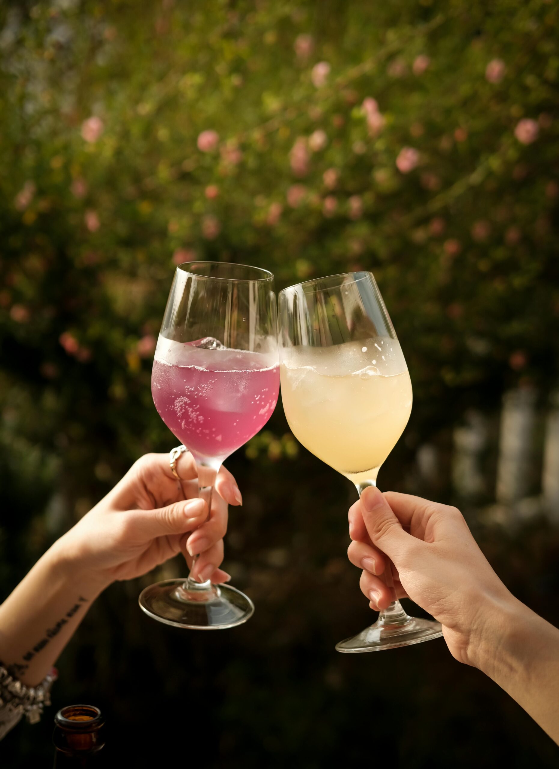 Two people toast with colorful drinks outdoors in Đà Lạt, Vietnam.
